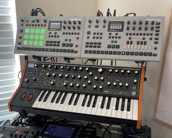 Two Elektrons (Analog Four MkII and Analog Rytm MkII) held above Moog Sub37 by KVgear SubPiggy stand -- front view