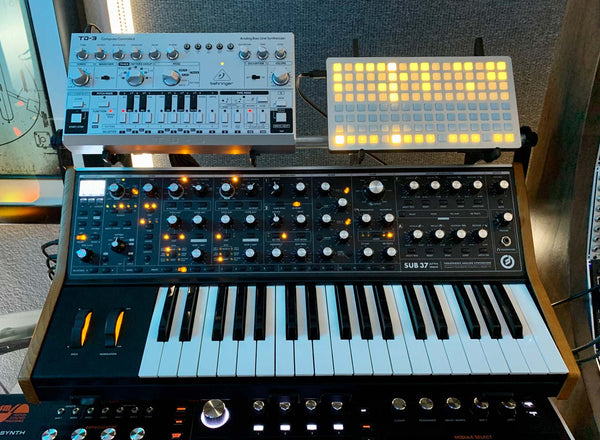 KVgear SubPiggy stand holding Behringer TD-3 and monome controller on a Sub37 synth -- front view