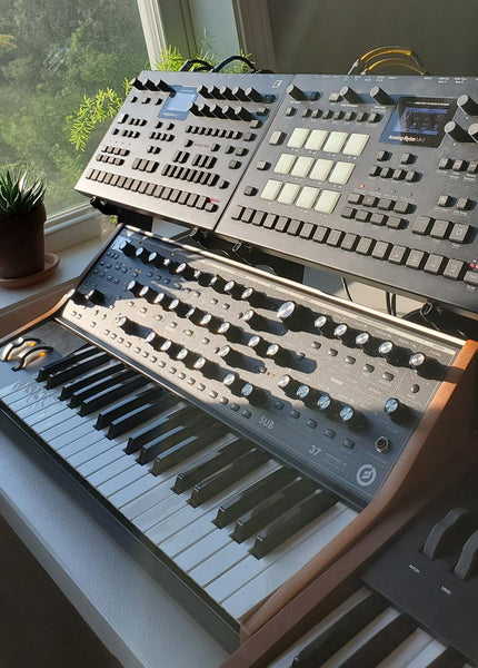 Two Elektrons (Analog Four MkII and Analog Rytm MkII) held above Moog Sub37 by KVgear SubPiggy stand -- side view
