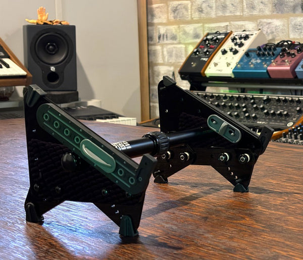 Adapt Legs raise a desktop synth stand above the table.